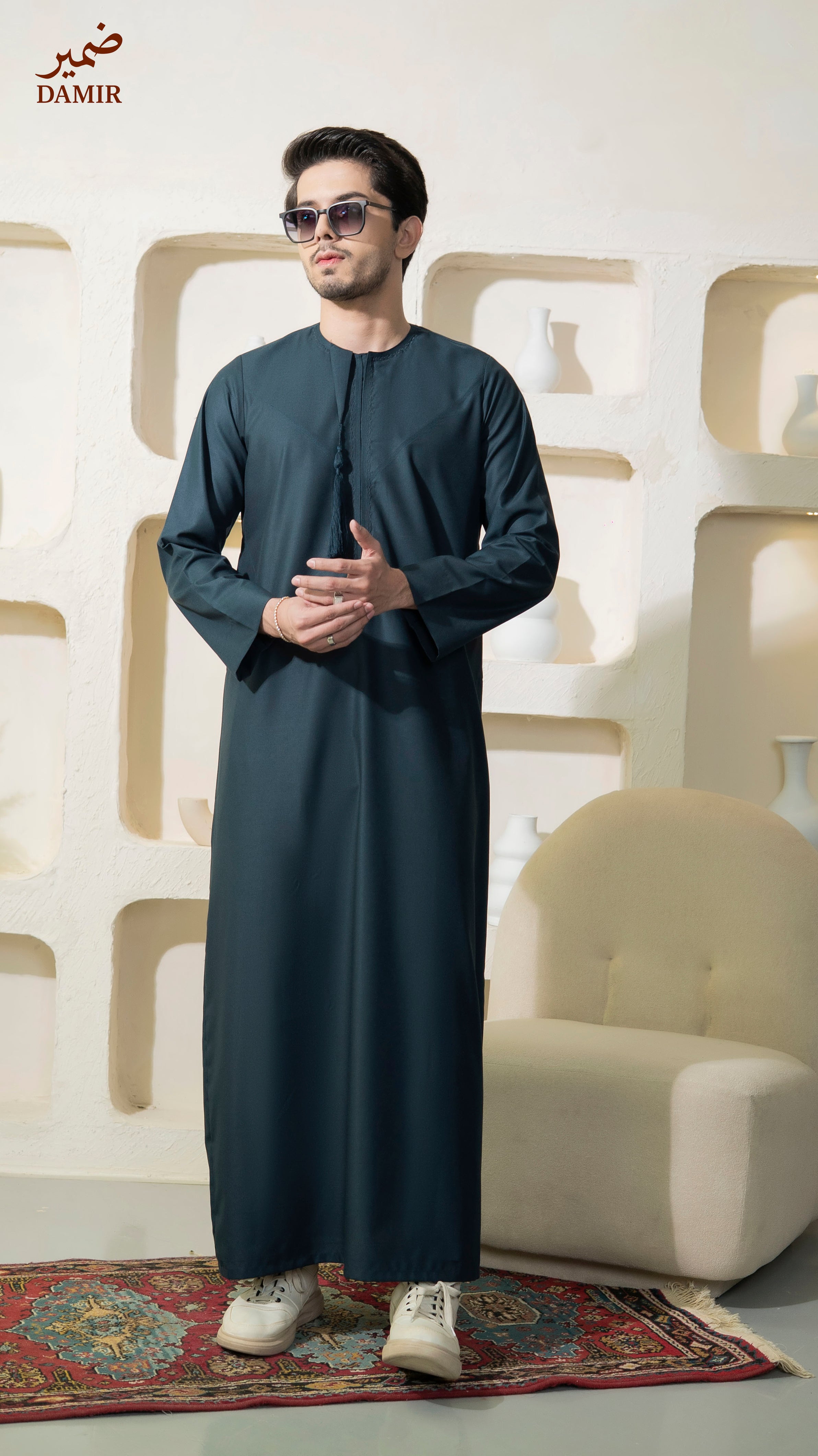 Man wearing a Sapphire traditional outfit standing in a room with decorative elements.