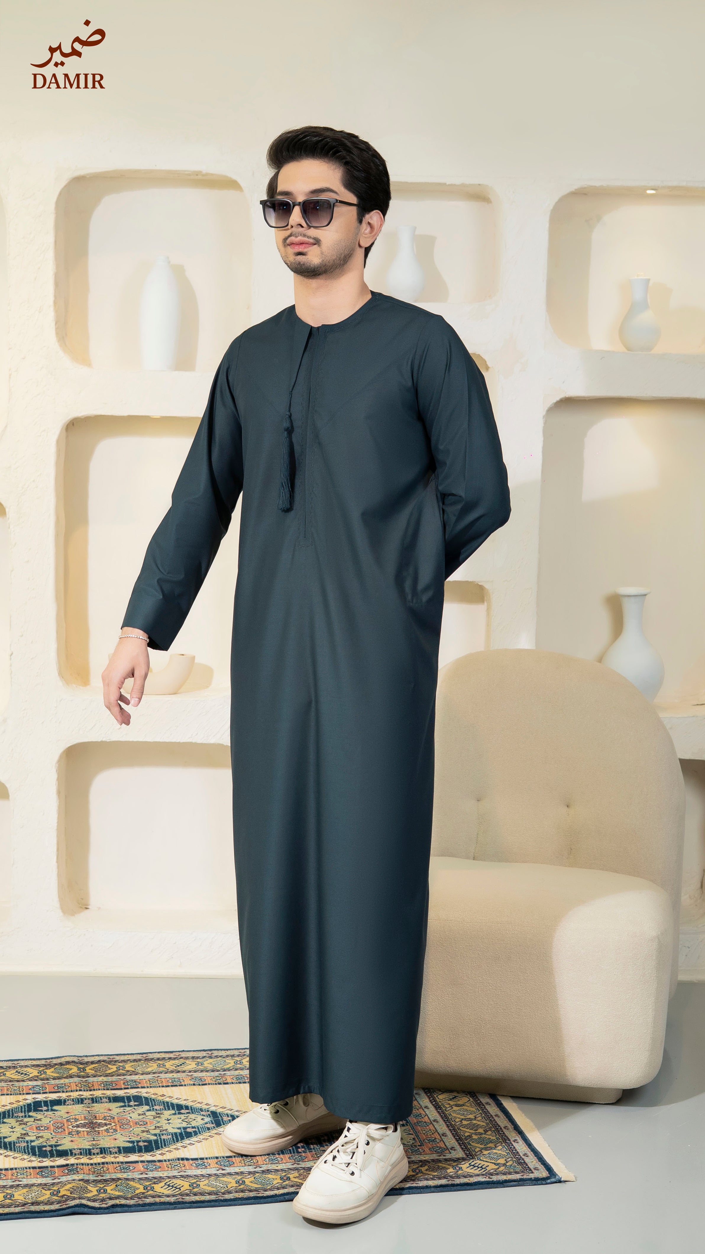 Man wearing a Teal traditional outfit in a modern interior setting with 'DAMIR' branding.
